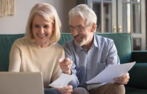 A couple at their laptop making a budget to track their financial life.