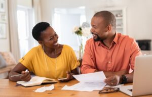 Two middle aged people learning how to become financially literate in their home.