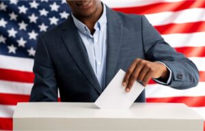 A man dropping a ballot into a voting box. But will this Presidential Election affect the stock market?