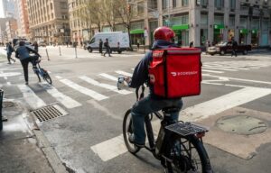 A doordash dasher rides his bike to deliver something as the stock IPOs on the new york stock exchange.